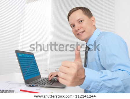 business man working on his laptop and showing thumbs up