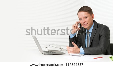 handsome business man using cell phone in office