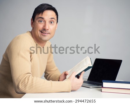 Portrait of handsome young man reading a book