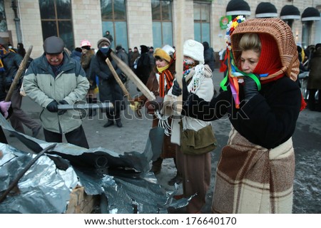 Woman with a basket on her head on metal bats. Kyiv, Ukraine, January 20, 2014