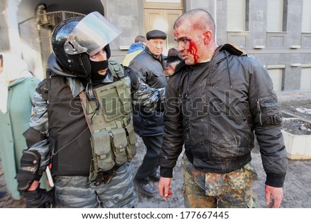 KIEV, UKRAINE - FEBRUARY 18, 2014: Policeman talks to protesters injured person. Kiev, Ukraine, Kiev, 18.02.2014