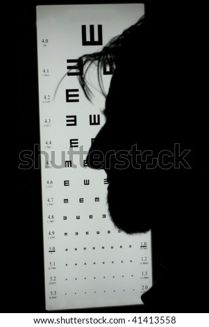 Male profile silhouette in front of eye chart