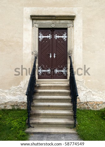 old wooden church door with stairs and banisters