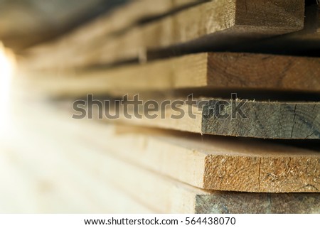 Stack of new wooden studs at the lumber yard. Wood timber construction material. Shallow depth of field effect