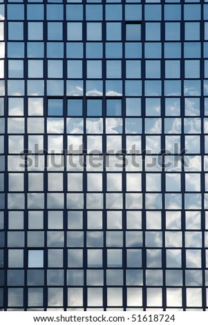 Mirror reflection of a cloudy sky in windows of an office building