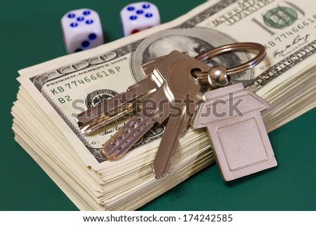 keys money and rolling dice on a green table, selective focus
