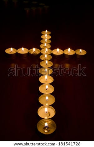 burning candles in the shape of a cross, selective focus