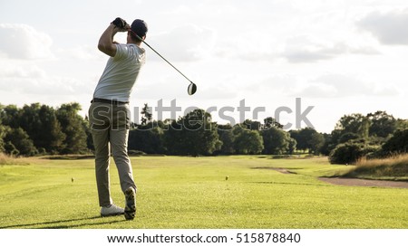 Man hitting driver on a golf course in the sun