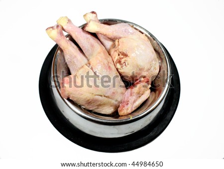 raw chicken legs in silver dog bowl