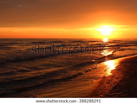 Sky of sea sunset. Beautiful summer golden sunset above the black sea.with calm waves and reflection of sun on the beach. Sochi, Russia