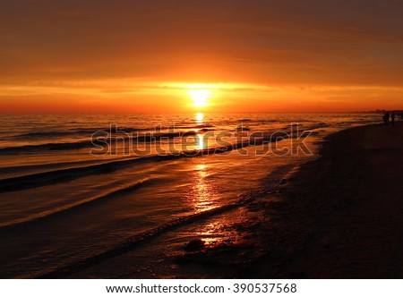 Beautiful blazing sunset view at black sea & orange sky above it and awesome sun gold reflection on calm waves. Amazing sunset view on the beach. Summer sea sunset wave & red sky Sea sunset background