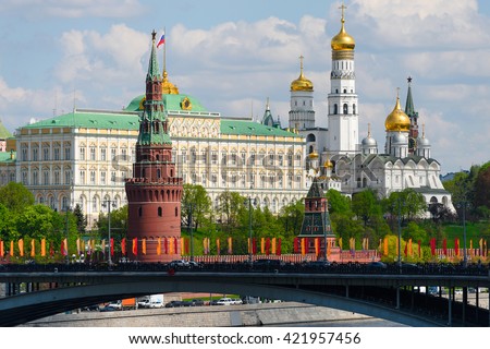Beautiful view of Moscow redbrick Kremlin landmarks at a day with bridge over Moscow river and blue sky as a background. Russia.