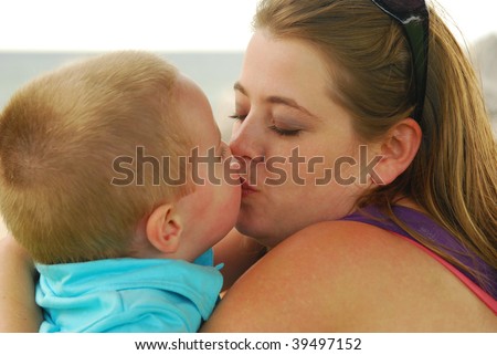 Mother kissing son , sallow depth of field, focus on mouth.