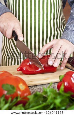 Man cutting sweet paper and vegetables in kitchen