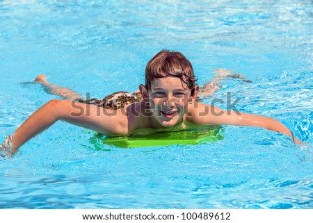boy in the pool relaxing on a surf board
