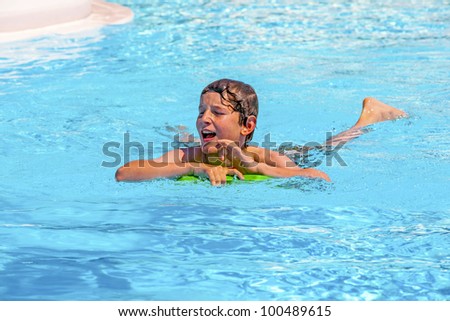 boy in the pool relaxing on a surf board