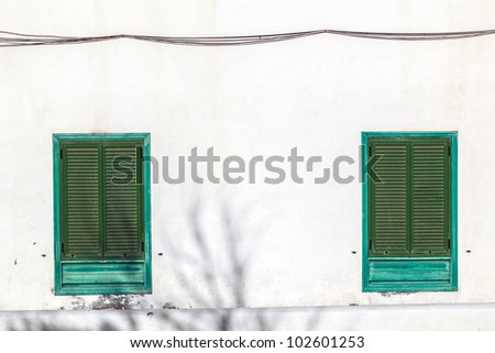 facade of mediterranean house with closed shutterblinds at midday