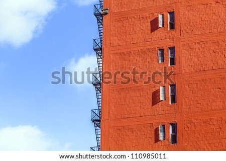 fire escape ladder at an old brick skyscraper