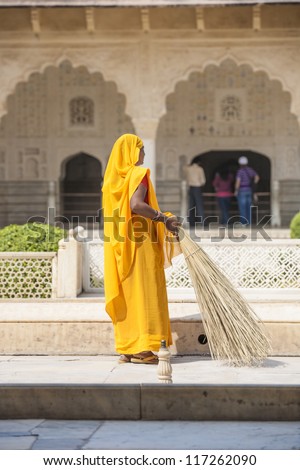 AMER, INDIA - NOV. 19: Unidentified woman of fourt class in brightly colored sari cleans the Amber palace on November 19,2012 in Amer,India. They earn 300 IRP for two hours paid by the government.