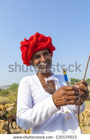 PUSHKAR, INDIA - OCTOBER 22: A Rajasthani tribal man wearing traditional colorful turban and loves to pose  at the annual Pushkar Cattle Fair on October 22, 2012 in Pushkar, Rajasthan, India.