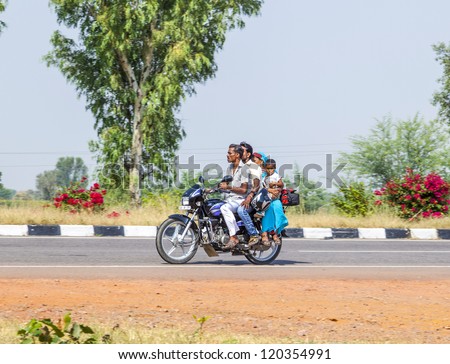 RAJASTHAN - INDIA - OCTOBER 18: Mother, father and small child ride on scooter on the highway on October 28, 2012 in Rajasthan, India. Up to six family members manage to ride these two wheelers.