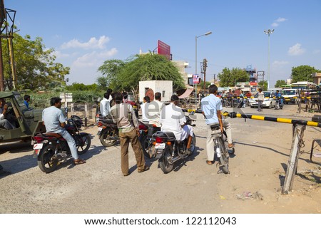 JAIPUR, INDIA - OCT 23: Indian Railway train passes a railroad crossing on Oct 23, 2012 in Jaipur, India. Indian Railways is one of the worlds largest railway networks comprising 115000 km of track.