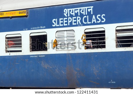 JAIPUR, INDIA - OCTOBER 23: passengers hanging at the window of a moving Indian Railway train on October 23,2012 in Jaipur, India. Indian Railways carries  about 7,500 million passengers annually.