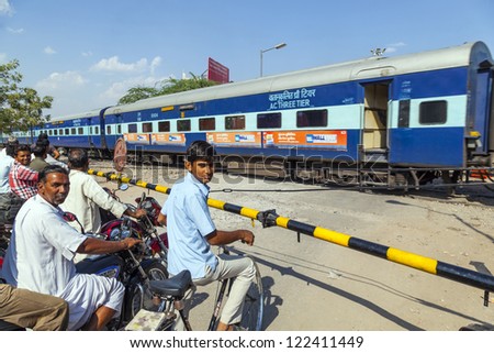JAIPUR, INDIA - OCTOBER 23: Indian Railway train passes a railroad crossing on Oct 23, 2012 in Jaipur, India. Indian Railways is one of the worlds largest networks comprising 115,000 km of tracks.