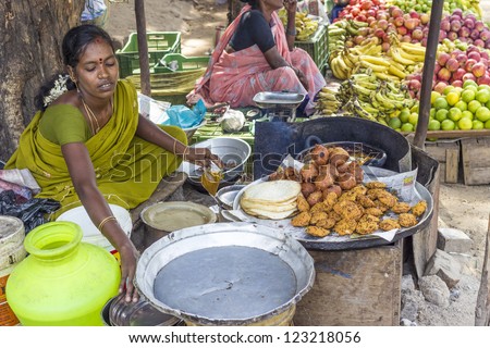 JAIPUR, INDIA - AUGUST 25: Indian women sells bread and fresh boiled cakes by on August 25, 2012 in Jaipur, India.  In India poor women often sell vegetables to earn a small cash income.