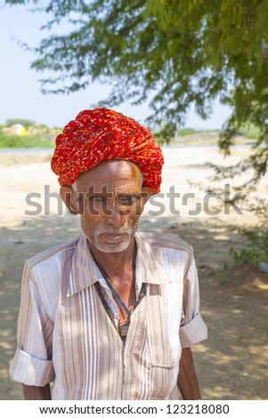 PUSHKAR, INDIA - OCTOBER 21: A Rajasthani tribal man wearing traditional colorful turban attends the annual Pushkar Cattle Fair on October 21, 2012 in Pushkar, Rajasthan, India.