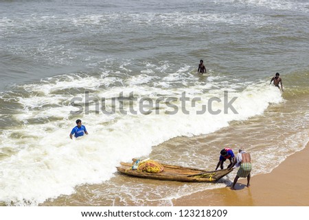 MAMALLAPURAM, INDIA - AUG 25: fishermen land with a bamboo boat at the beach without catch on Aug 25,2012 in Mamallapuram, India. Fishing in India is a major industry employing over 14 million people.