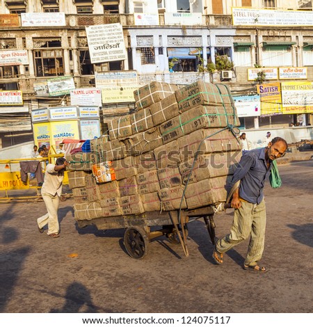 DELHI, INDIA - OCT 16: Rickshaw rider transports heavy goods  on OCT 16,2012 in Delhi, India. Cycle rickshaws were introduced in to Delhi in the 1940's and have a fixed quota of licenses.