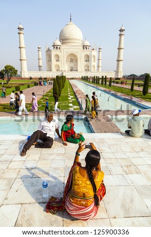 AGRA, INDIA - OCT 18: people visit Taj Mahal, Agra, India on Oct 18, 2012. The Taj Mahal is a mausoleum located in Agra and one of the most recognizable structures in the world