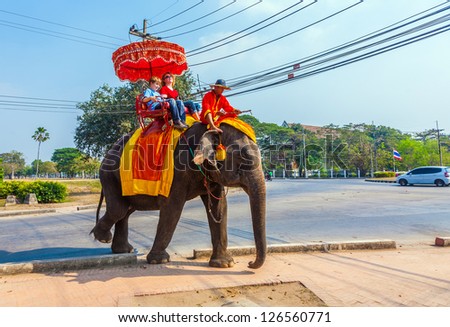 AYUTTHAYA, THAILAND DEC 23: unidentified tourists ride on elephant in the Historical Park on DEC 23, 2009 in Ajutthaya, Thailand. It is called a must in Ayutthaya and costs about 1000 BATH for 30 min.