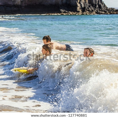 boys have fun riding in the waves