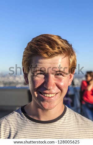 portrait of handsome boy with red hair under blue sky