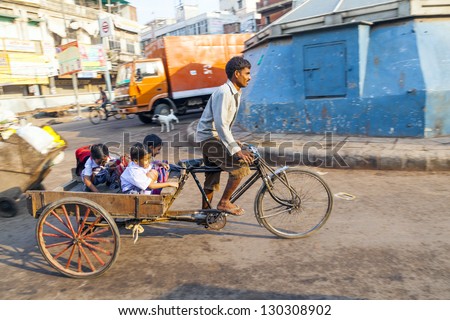 DELHI, INDIA - OCT 16: Unidentified father transports his children on October 16, 2012 in Delhi, India. Cycle rickshaws were introduced in to Delhi in the 1940\'s by the British to increase transport capacity.