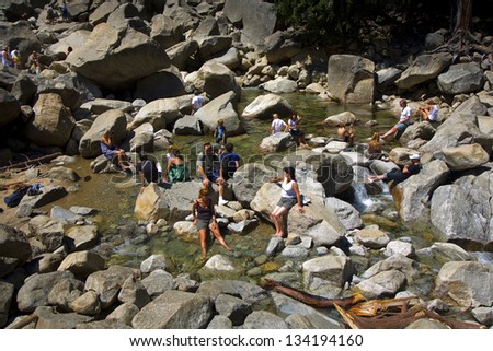 YOSEMITE PARK, USA - JULY 22: tourists cool their legs in the lake of the lower Yosemite waterfall on July 22, 2008 in Yosemite, USA. In 1890, the U.S. Congress declared that area as National park.