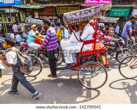 DELHI, INDIA - OCT 10: Rickshaw rider transports passenger on October 10,2012 in Delhi, India. Cycle rickshaws were introduced in Delhi in the 1940\'s and have a fixed quota of licenses.