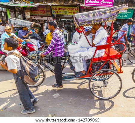 DELHI, INDIA - OCT 10: Rickshaw rider transports passenger on October 10,2012 in Delhi, India. Cycle rickshaws were introduced in Delhi in the 1940\'s and have a fixed quota of licenses.
