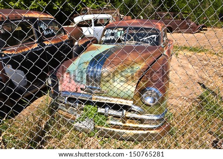 GLENDALE, USA - JULY 17: junk yard with old rotten rusty classic cars on July 17, 2008 in Glendale, USA. The price of the wrecks is written on the window shield, cars stand outside without protection.