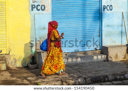 JAIPUR, INDIA - OCTOBER 12: closed shops on Friday at 8am on October 19, 2012 in Jaipur, India. For Hindi people, Friday is the holy day of rest. Woman walks in front of closed shops.