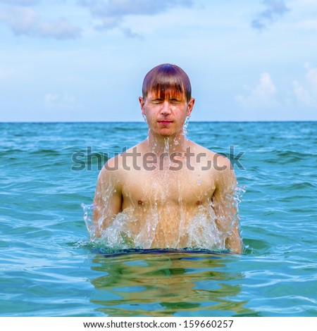boy jumps out of the water at the warm atlantic ocean
