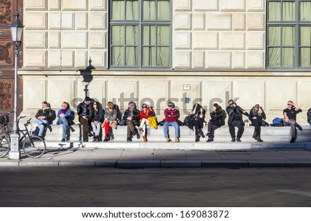 MUNICH, GERMANY - DEC 27: people in the sun in front of residence on  Dec 7, 2013 in Munich, Germany.  The Residenz is the largest city palace in Germany and   open to visitors.