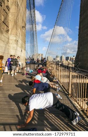 NEW YORK, USA - JULY 7: people exercise push-up at Brooklyn bridge in late afternoon on July 7,2010, New York. Brooklyn Bridge was constructed under Roebling\'s 1840 patent for the spinning wire rope.