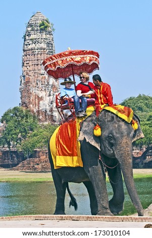 AYUTTHAYA, THAILAND - DEC 24:  tourists on an elefant ride  on December 24, 2009 in Ajutthaja,Thailand. Elephant ride costs 1100 baht per person in the  Ayutthaya Historical Park.