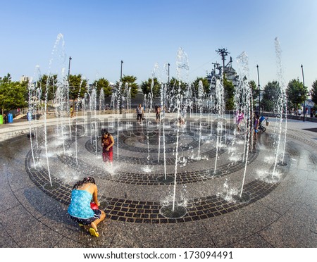 NEW YORK, USA - JULY 8: people in the public fountain area have a refreshing bath at the east harbor side in late afternoon on July 8,2010 in New York, USA.