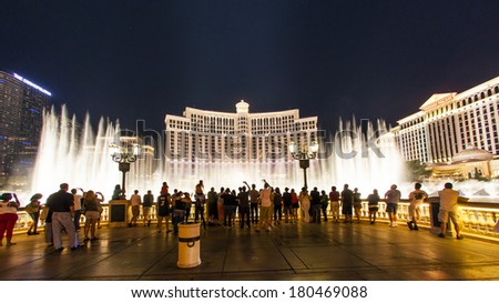 LAS VEGAS - JUNE 15: people watch the famous fountain show at Las Vegas Bellagio Hotel Casino at night on June 15, 2012 in Las Vegas, Nevada.