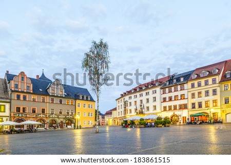 WEIMAR, GERMANY - MAY 27: people enjoy sunset at central market place on May 27, 2012 in Weimar, Germany.  The houses around the market place are old historic originals from the 18th century.