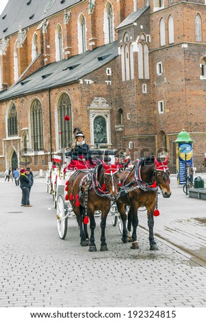 KRAKOW, POLAND - MAY 4: Horse-drawn carriage at the Market Square, standardized the color, total length of no more than 7.0 m, can be harnessed to a max of two horses on May 4, 2014 in Krakow, Poland.